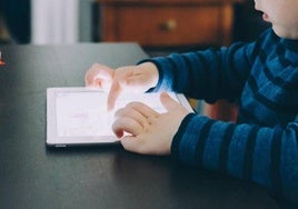 Un niño usa una tablet.