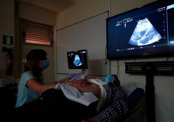 Una profesional practica la ecografía clínica en el aula de San Juan con un paciente real.