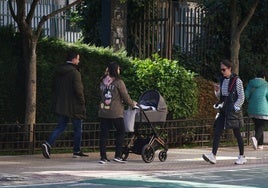 Una pareja pasean con un recién nacido.