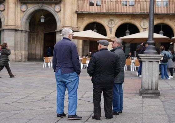 Un grupo de mayores paseando por la Plaza Mayor.