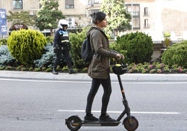 Una joven circula con el casco en el manillar de su patinete.