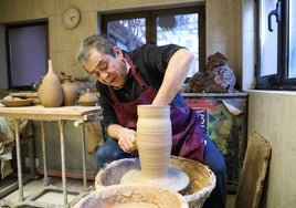 El artista Gerardo Cambronero moldea una pieza de arcilla en su taller.