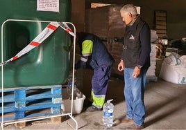 Un vecino de Rollán cogiendo agua potable del depósito instalado en la nave municipal.