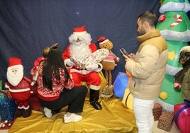 Papa Noel entrega un regalo a uno de los niños que le visitaron en la sede de Los Praos.