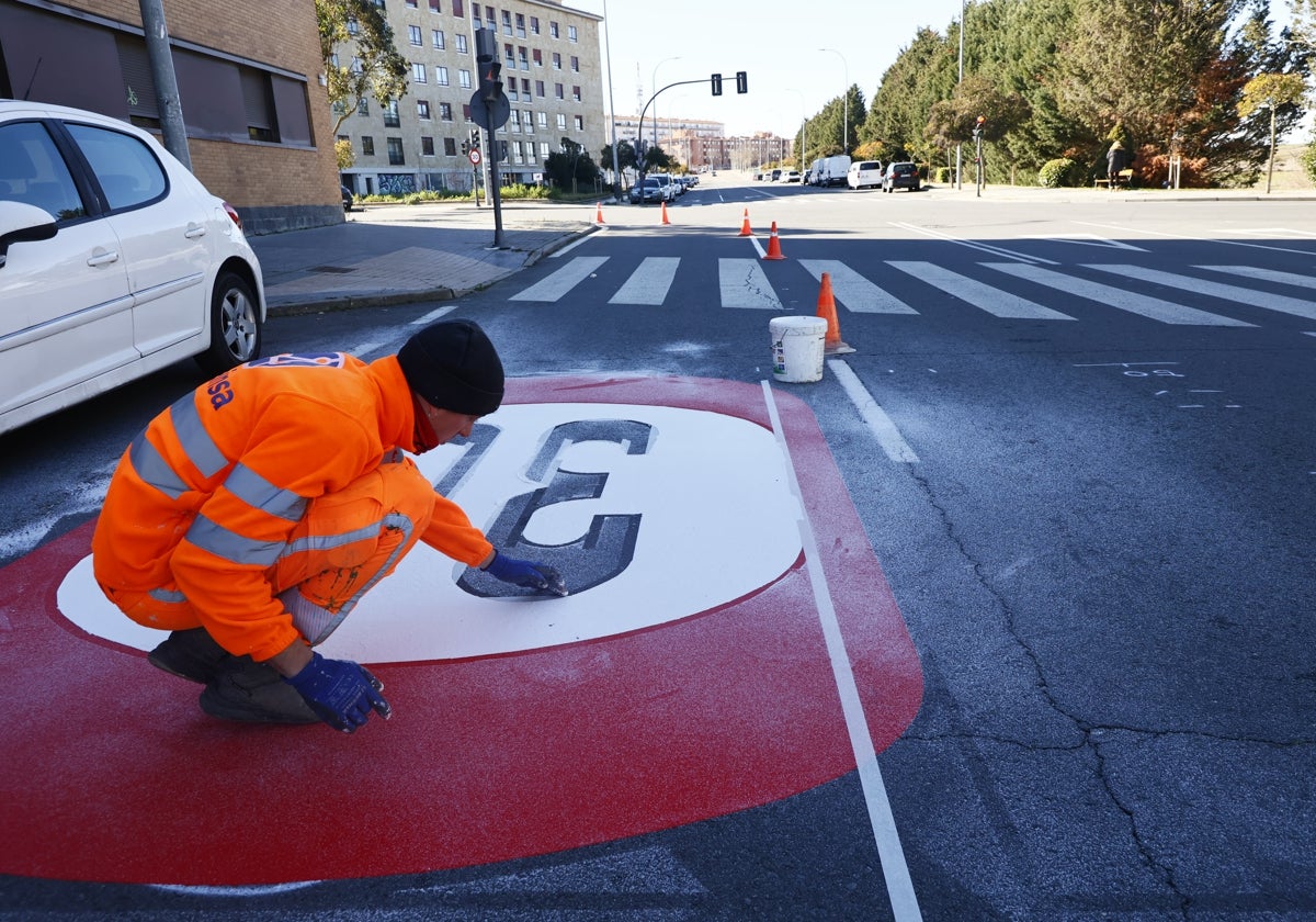 Un operario pinta la señal de límite de velocidad a 30 km/h en la calle Babia.