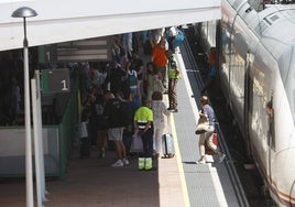 Viajeros bajando del tren en la estación de trenes.