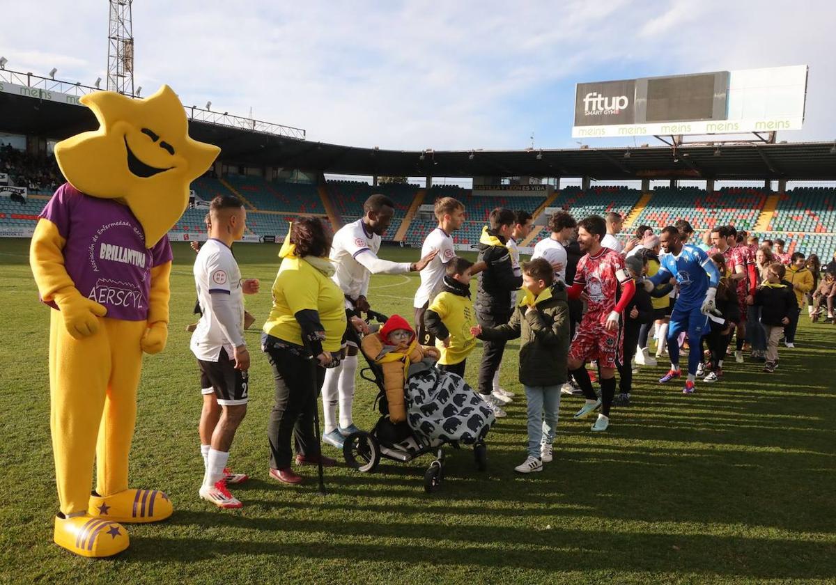 Imagen de algunos integrantes de la Asociación de Enfermedades Raras de Castilla y León junto a los jugadores del Salamanca UDS y del Club Deportivo Guijuelo, en el Estadio Helmántico.