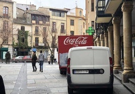 Un camión y una furgoneta de reparto, aparcados en el casco histórico.