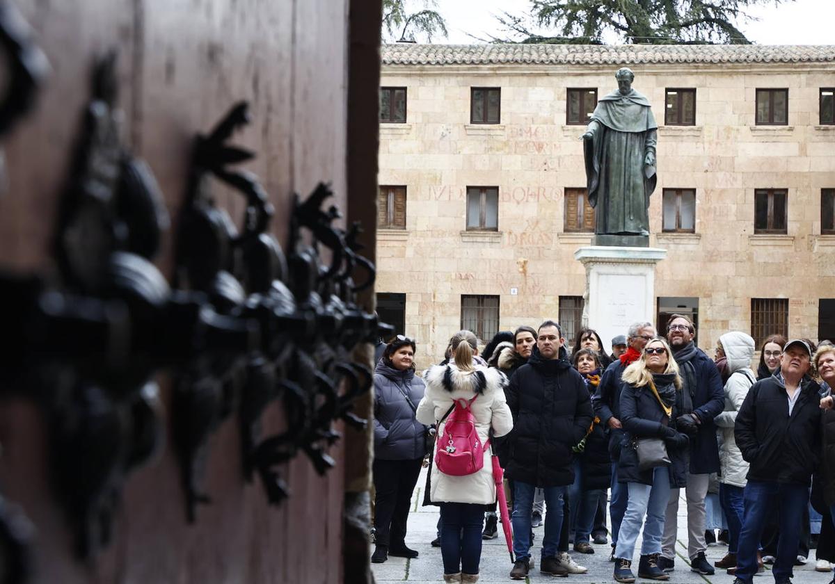 Algunos turistas miran atentamente la fachada de la Universidad.