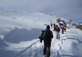 Un grupo de personas caminan por la nieve.