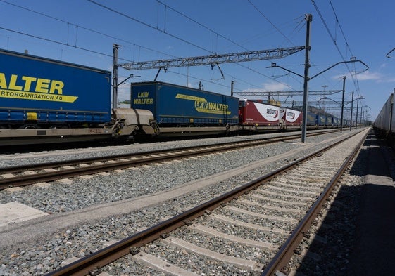 Semirremolques de camiones sobre un tren en una autopista ferroviaria.