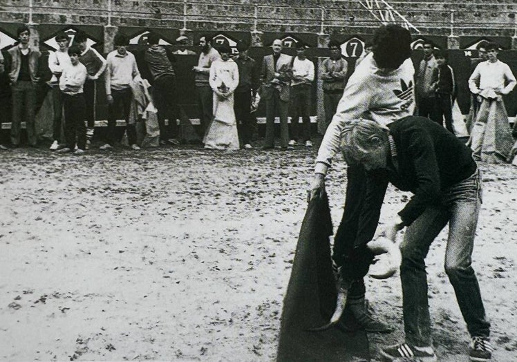 Julio Norte torea de salón ante las «embestidas» de su compañero, El Rubio de La Glorieta, en la primera clase celebrada en La Glorieta el 1 de abril de 1985, ante la atenta mitrada de profesores y alumnos al fondo de la imagen.