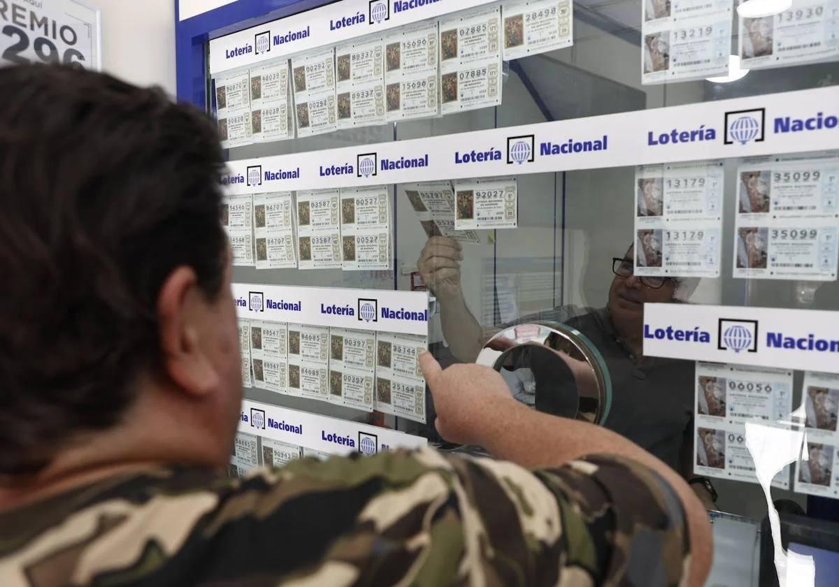 Hombre comprando lotería nacional en una adminitración salmantina.