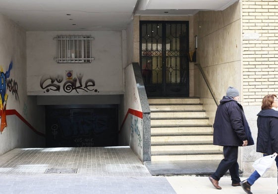 Una pareja pasa frente a un portal con escaleras para acceder al edificio en un barrio de Salamanca.