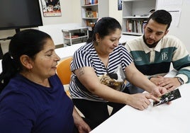 Carmen Jiménez, Ignacia Jiménez y Luis Garrote observan una fotografía de Luis de pequeño.