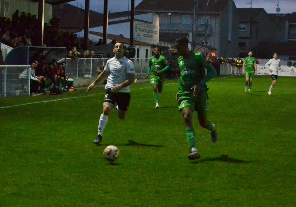 Alberto pugna por un balón con un defensor visitante.