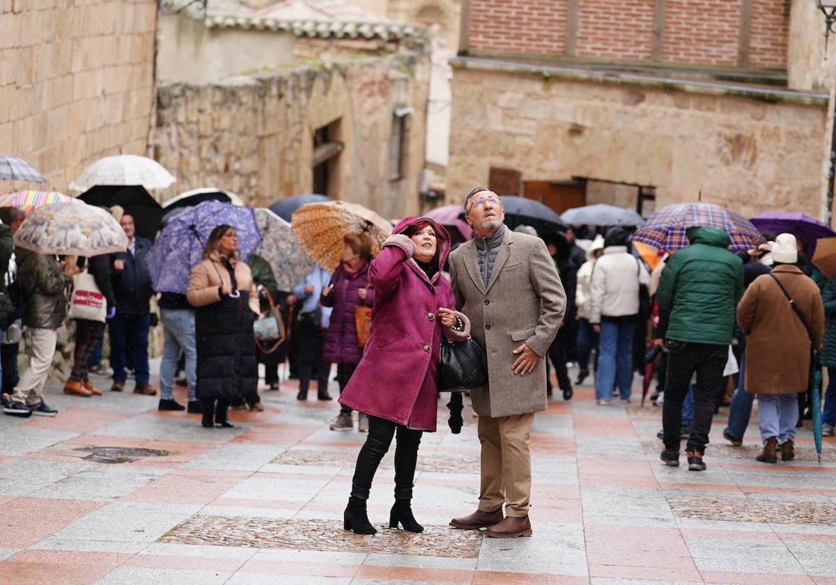 Turistas miran preocupados al cielo en un día de lluvia en Salamanca.