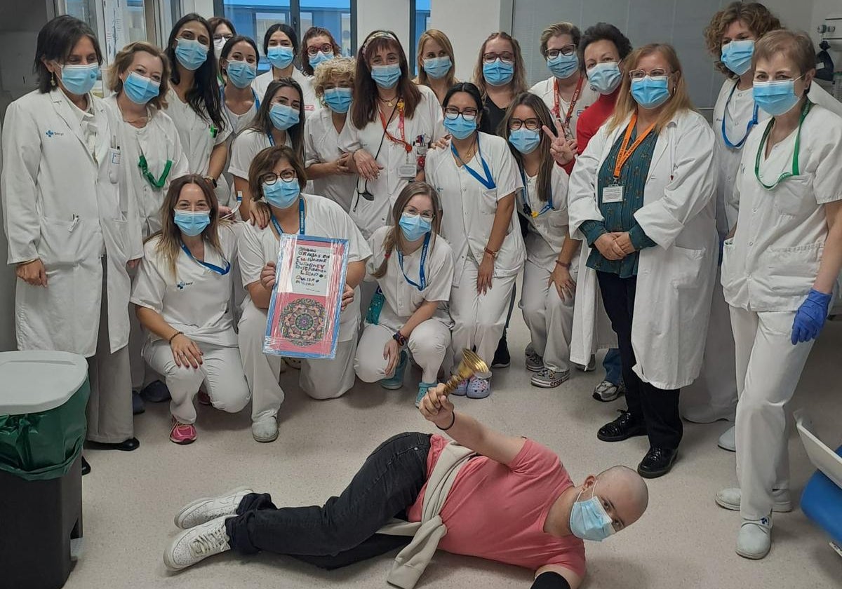 El joven Pablo Pascual toca la 'campana de la victoria' junto a su familia y al personal sanitario en el Hospital de Salamanca.