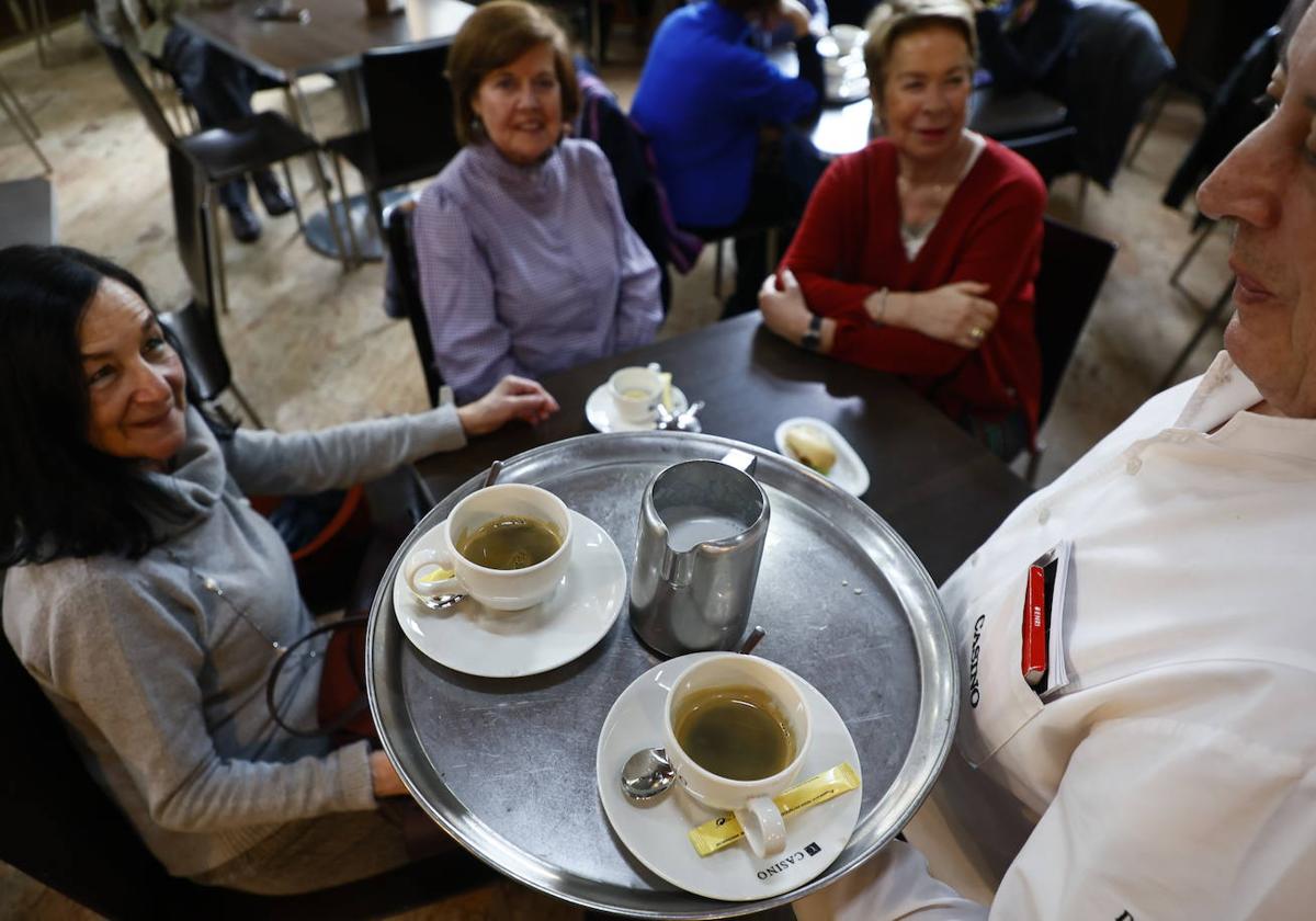 Un camarero sirve café a unas clientas en un establecimiento de hostelería del centro de Salamanca.