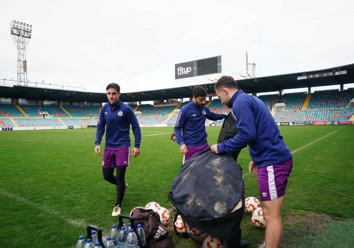 Tomás Berardozzi, Diego Benito y Parra vaciando las sacas de balones antes de la sesión de trabajo.