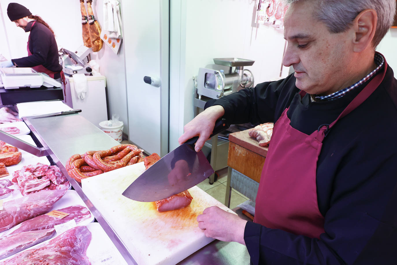 Agustín Vicente, partiendo filetes de lomo adobado en su carnicería.