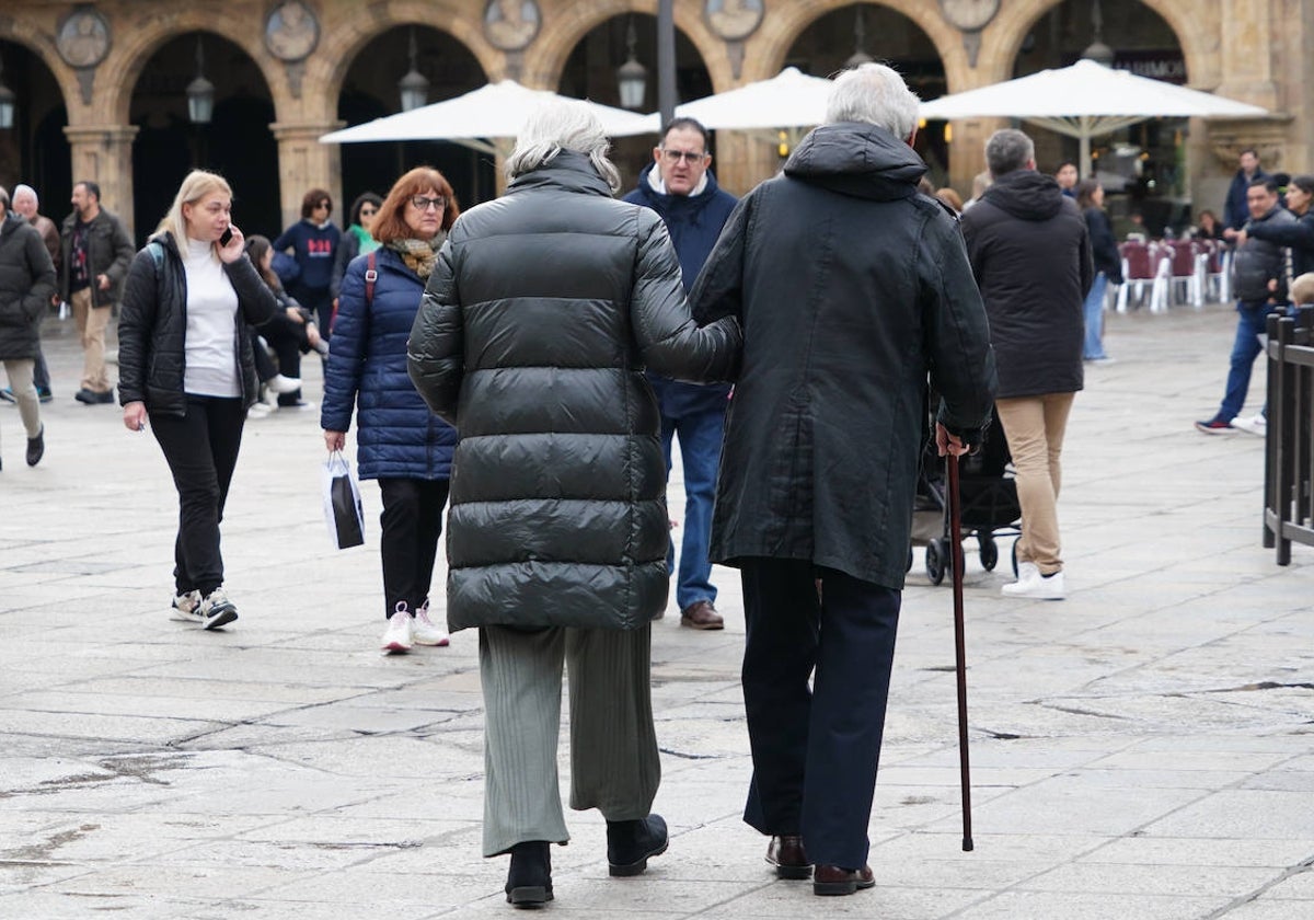 Una mujer y un hombre mayores paseando por la Plaza.