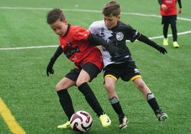 Dos jugadores, del Calasanz y Unionistas, pelean por hacerse con el control del balón durante el encuentro.