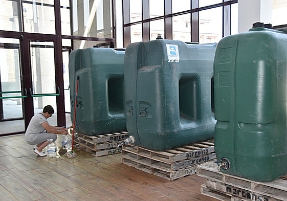 Una vecina cogiendo agua en los depósitos instalados en Ledesma en verano por el agua no potable.