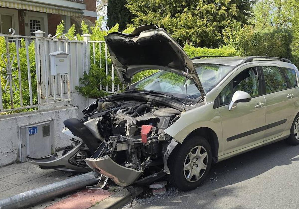 El coche de la mujer, destrozado tras colisionar contra la farola.