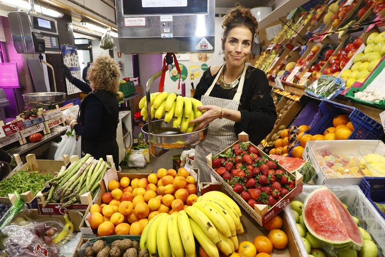 Susana, frutera del Mercado Central, sostiene unos plátanos.