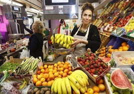 Susana, frutera del Mercado Central, sostiene unos plátanos.