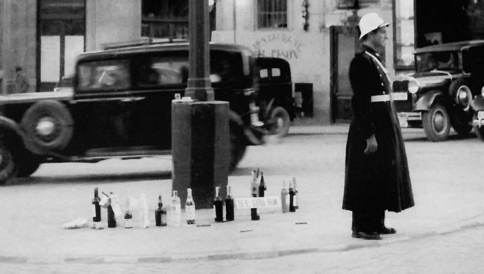 Las botellas de licor donadas por los salmantinos rodean la farola en el puesto de trabajo de este guardia en Poeta Iglesias.