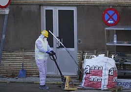 Un operario protegido retira material con amianto.