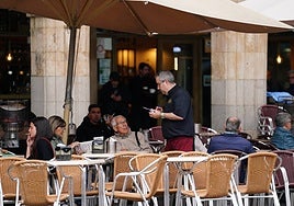 Un camarero tomándole el pedido a unos clientes en una terraza en el centro de la ciudad.