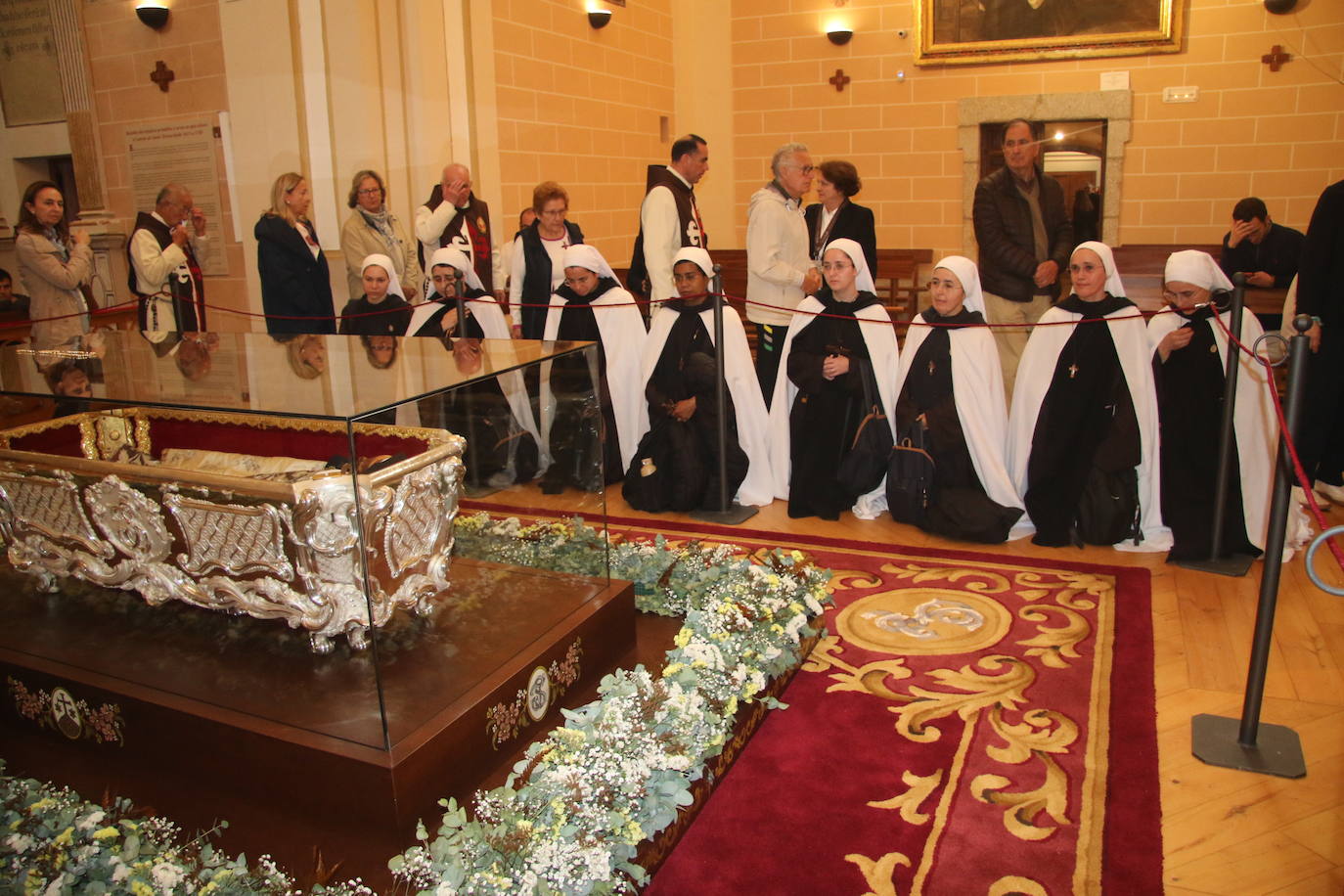 Las integrantes del instituto Hesed de Portugal, de rodillas ante la urna de Santa Teresa.