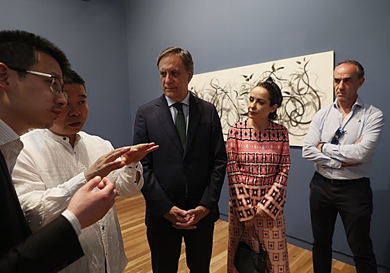 El artista Xú Héng explica su obra al alcalde, Carlos García Carbayo, y la concejala, Carmen Seguín.