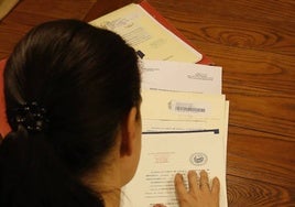 Una mujer revisando la escrituras de una vivienda.