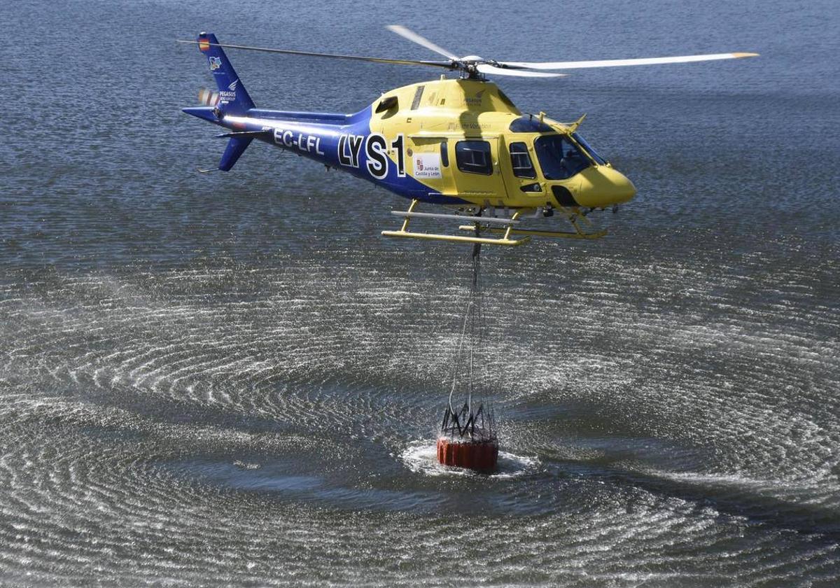 Un helicóptero coge agua en una balsa de la provincia para extinguir un incendio.