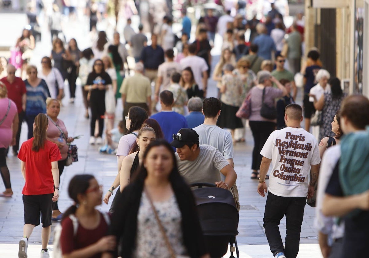 Decenas de personas caminando por el centro de la ciudad.