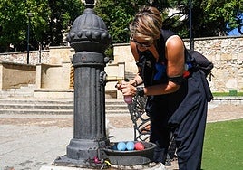 Una mujer llena unos globos de agua para combatir el calor.