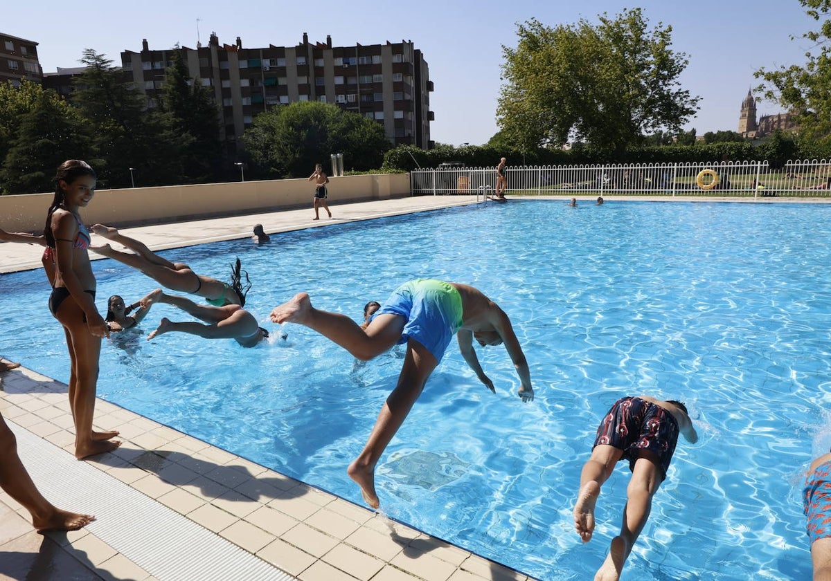 Bañistas saltando a la piscina.