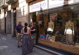 Comerciantes de la calle Zamora, en una tienda con el cartel 'El Ayuntamiento nos ignora'.
