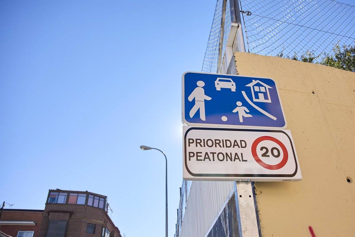 Una señal de tráfico indica la presencia de una zona peatonal y la obligatoriedad de circular a 20 kilómetros por hora en las inmediaciones de un colegio público.