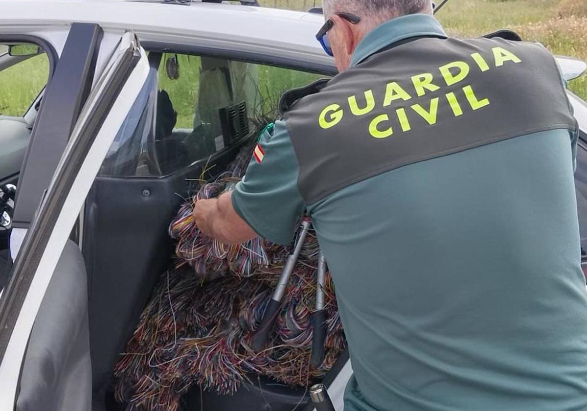 Un agente de la Guardia Civil muestra parte del cableado intervenido en la operación que ha permitido desarticular una banda este junio.