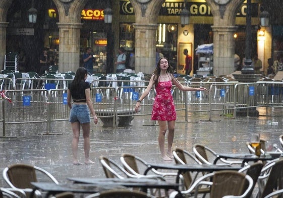 Dos jóvenes, bajo la lluvia en Salamanca.