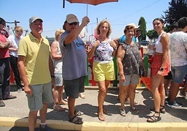 Un grupo de vecinos de Pelabravo, en la cola de la parrillada con la sombrilla.