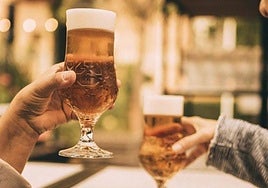 Dos personas brindan con cerveza.