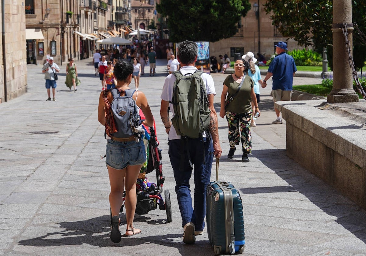 Turistas cargados con sus maletas en la plaza de Anaya este domingo.