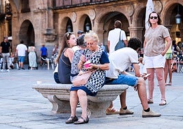 Una mujer combate el calor con un helado en la Plaza Mayor de Salamanca.