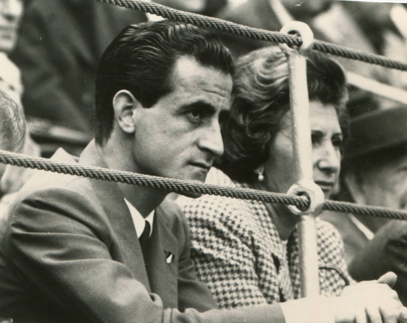 Un jovencísimo Santiago Martín viendo los toros desde la barrera.